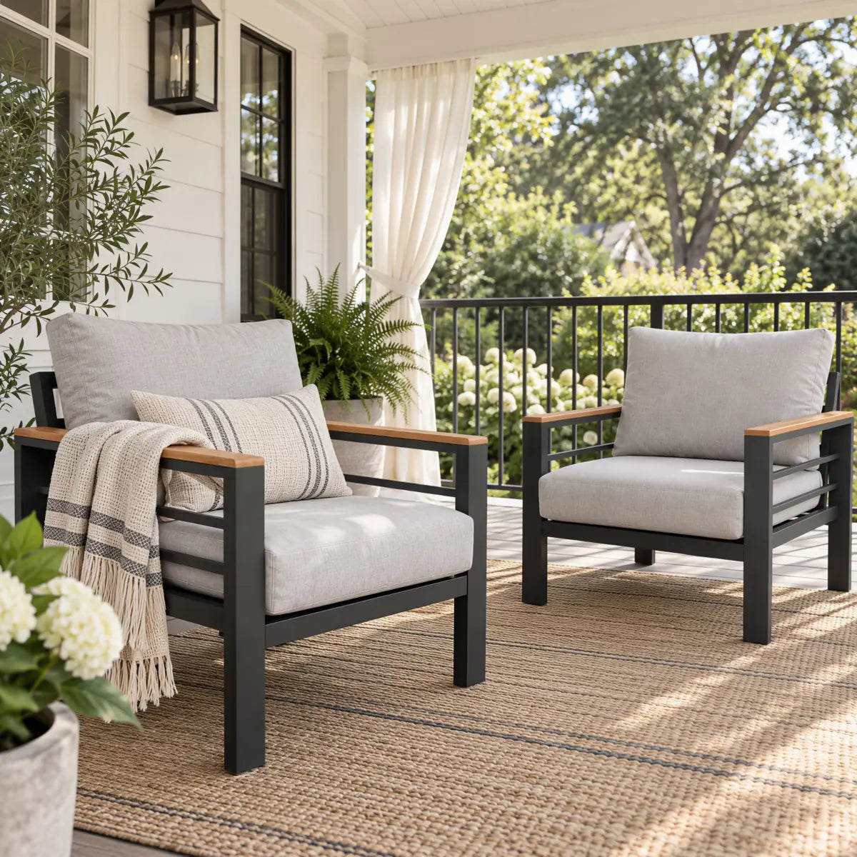 Two outdoor aluminum patio armchairs on a covered porch