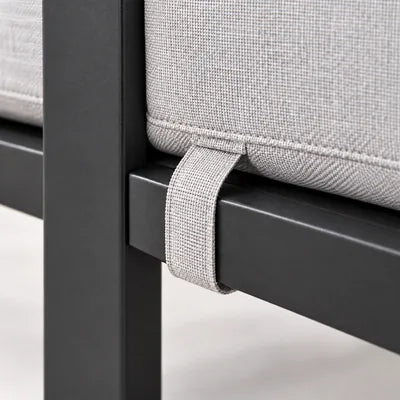 Outdoor sofa cushion tie strap securing the seat cushion to the metal frame