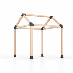 Angled view of an assembled wooden pergola frame built with a peaked-roof bracket kit, showing four posts, black roof connectors and post bases.